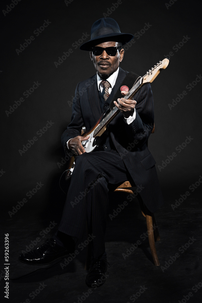 Retro senior afro american blues man. Wearing striped suit with