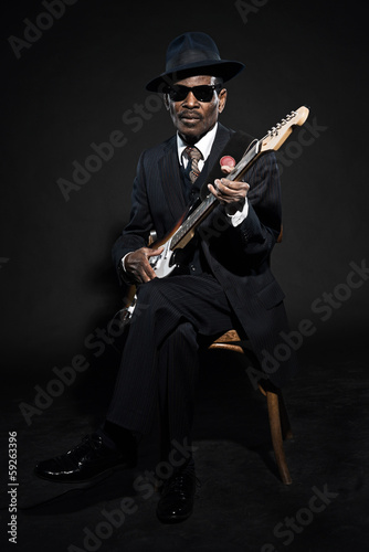 Retro senior afro american blues man. Wearing striped suit with