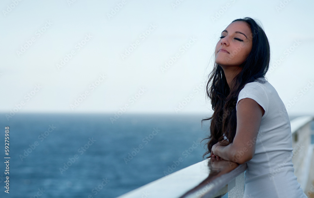 Woman enjoying the fresh sea air with closed eyes