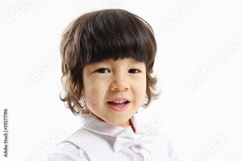 Face of little cute smiling boy in bow-tie on white background. photo