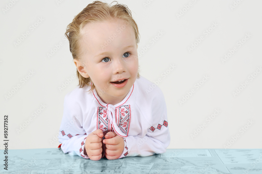 Little boy in Russian national costume and big map on white Little boy in Russian national costume and big map on white