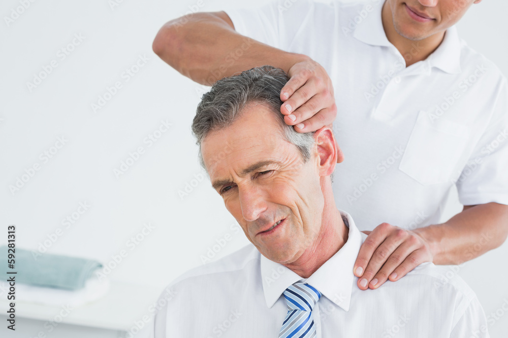 Fototapeta premium Male chiropractor doing neck adjustment