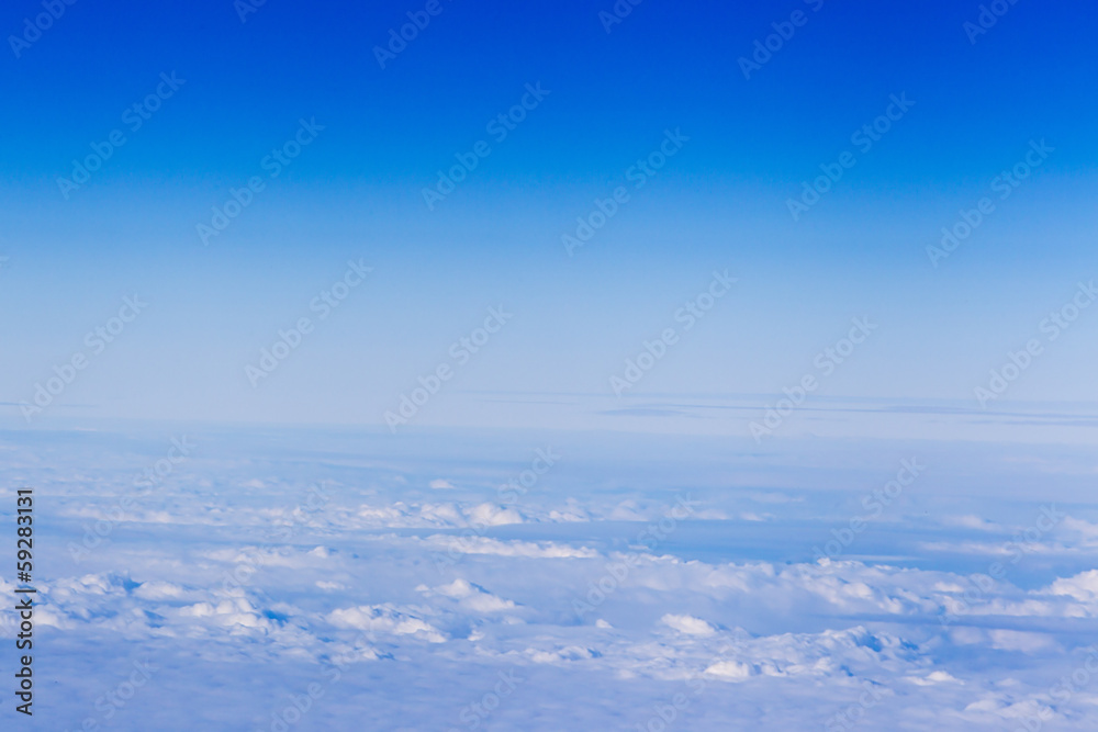 clouds. top view from the window of an airplane flying in the cl clouds. top view from the window of an airplane flying in the cl