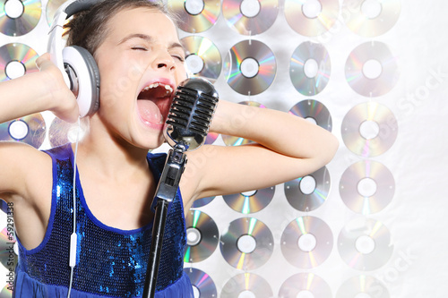 Dziewczynka w niebieskiej sukience śpiewa karaoke