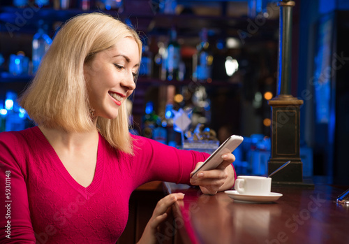woman with a cup of coffee and cell phone