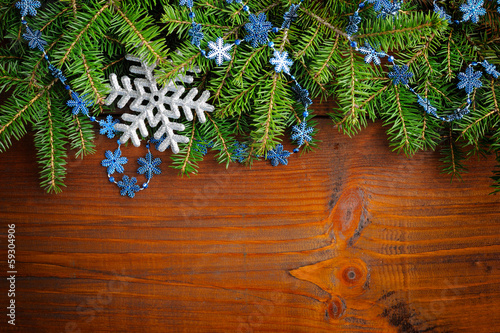 Branches of fir with christmas decorations on wooden background