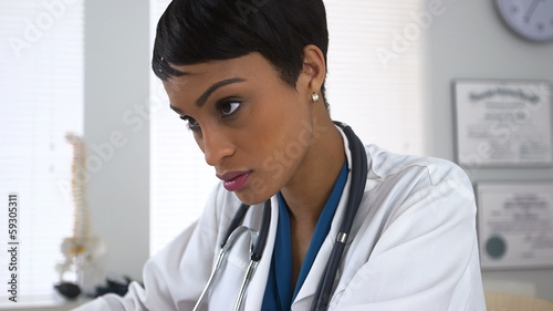 Doctor working and taking notes at desk