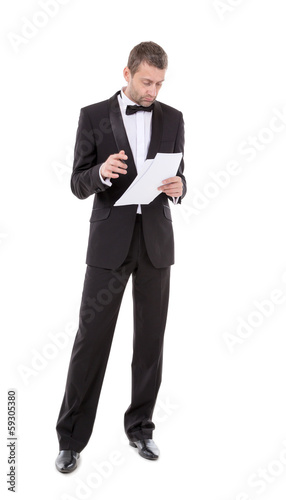 Man in a tuxedo reading the document © Discovod