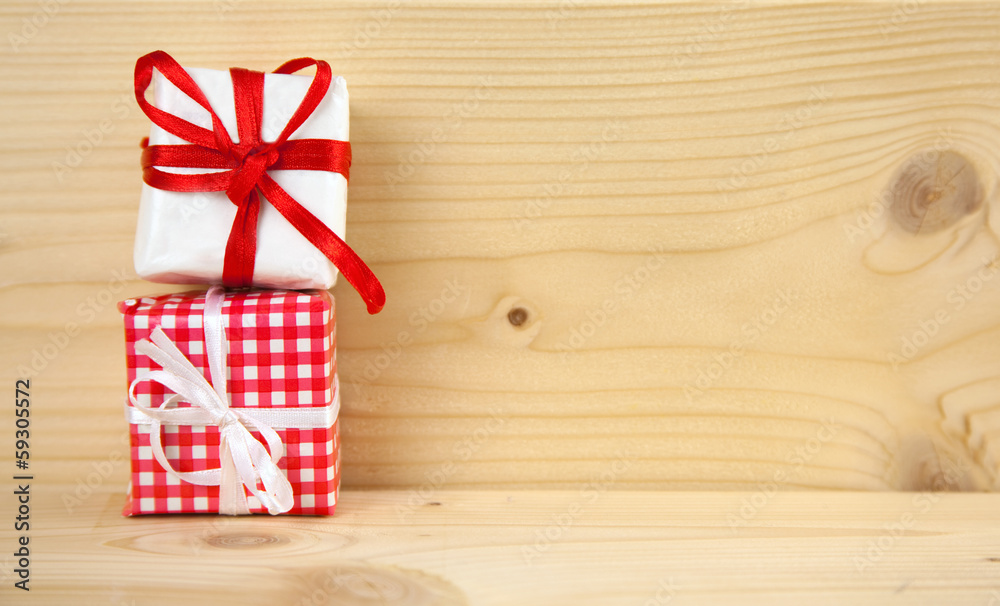 Obraz premium Rot-weiße Päckchen als Geschenke vor Holzhintergrund