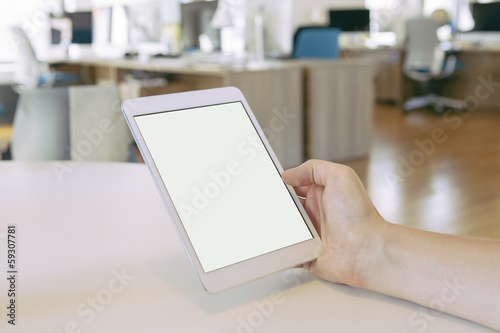Person in the office holding a touch screen device.
