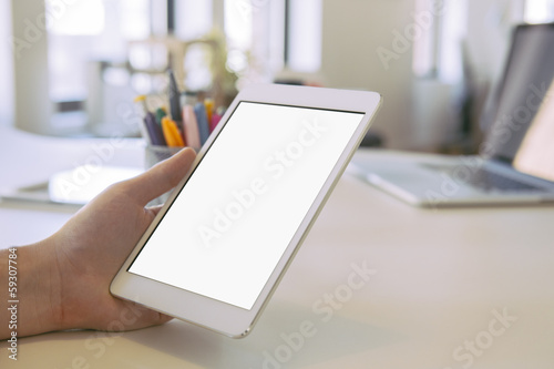 Person in the office holding a touch screen device.