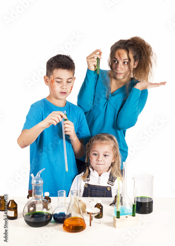 Three children working with chemical liquids at lesson Crazy