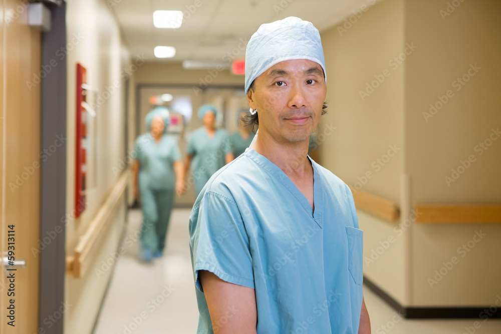 Surgeon With Team Walking In Hospital Corridor