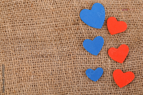Hearts made of felt on sacking background