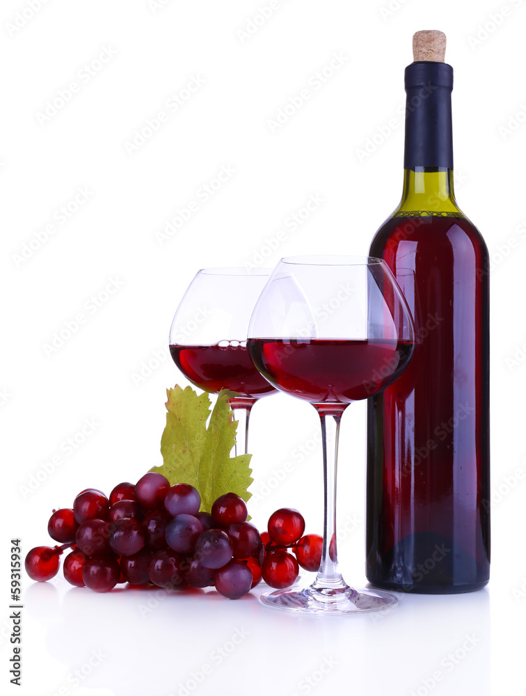 Wineglasses with red wine, grape and bottle isolated on white