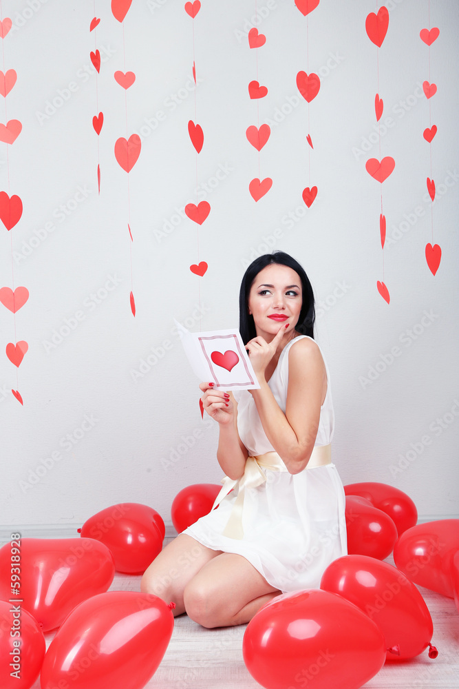 Attractive young woman read card in decorated room Attractive young woman read card in decorated room