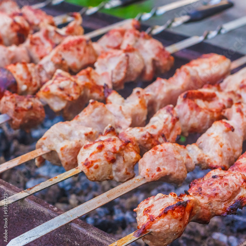 shish kebab in process of cooking on open fire outdoors