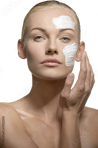 woman applying cream on face