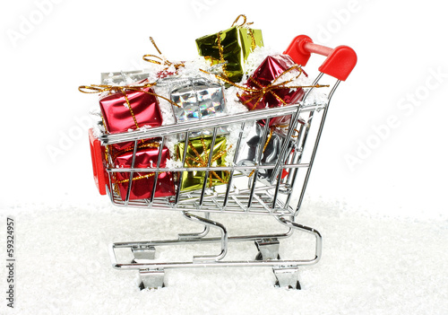 Shopping cart with Christmas gifts on white background.