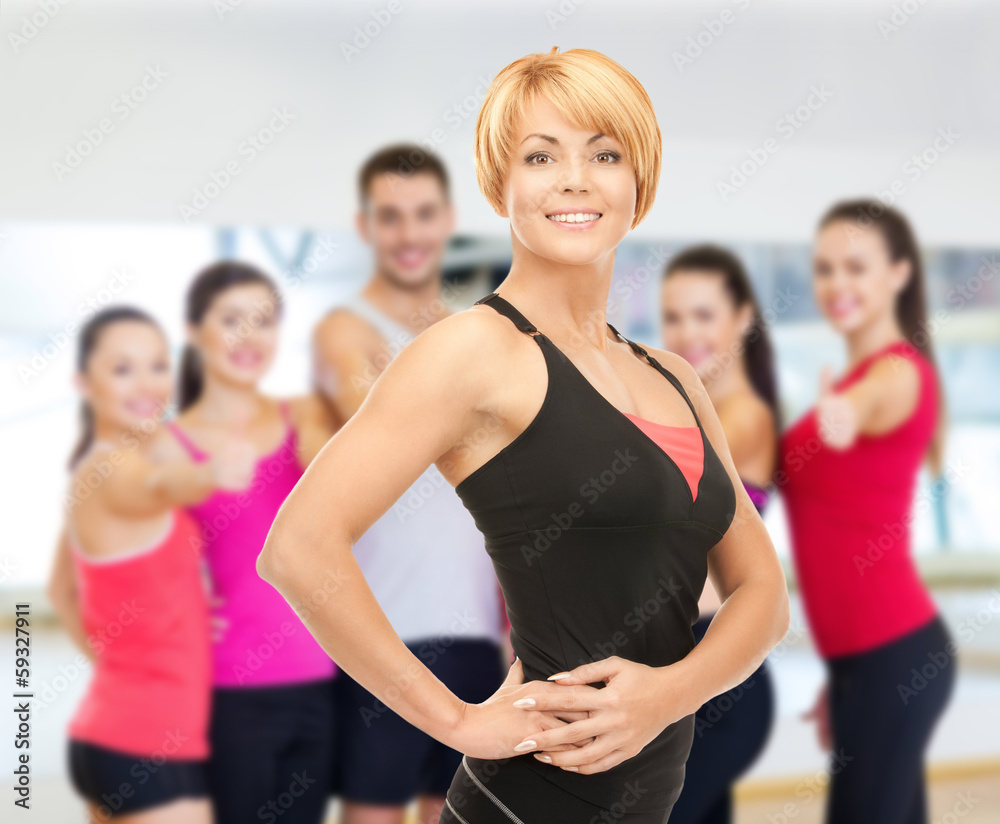 group of smiling people exercising in the gym