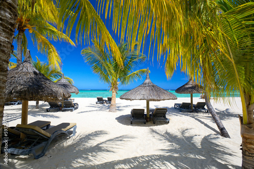 Lounge chairs with umbrellas on white sand beach, Mauritius photo