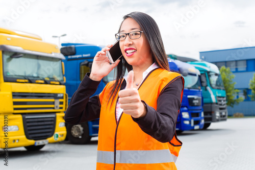 Konstfotografi Female forwarder in front of trucks on a depot