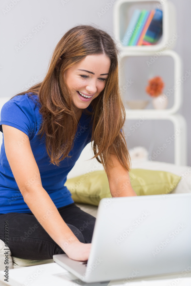 Smiling woman using laptop at home Smiling woman using laptop at home