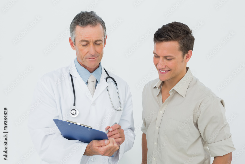 Doctor discussing reports with patient in office Doctor discussing reports with patient in office