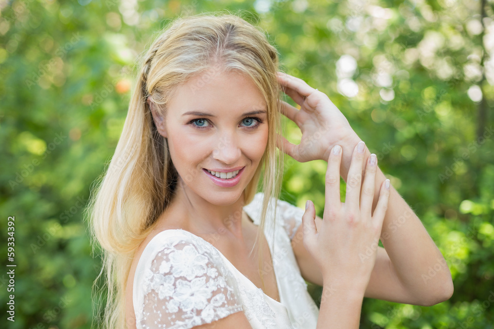 Happy beautiful bride touching her hair looking at camera Happy beautiful bride touching her hair looking at camera