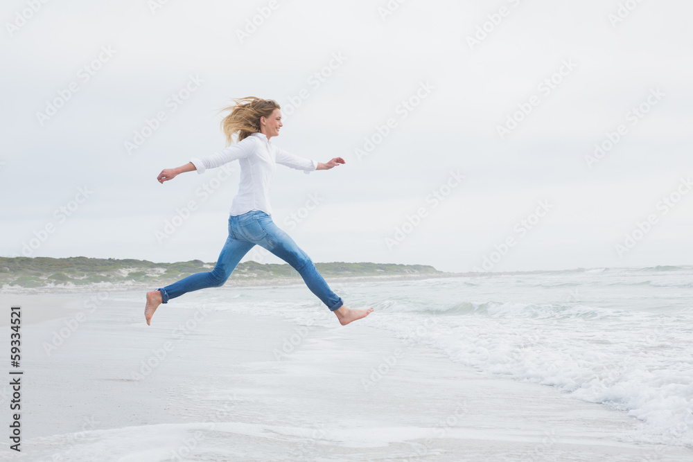 Side view of a casual woman jumping at beach Side view of a casual woman jumping at beach