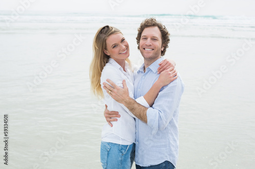 Happy romantic couple embracing at beach