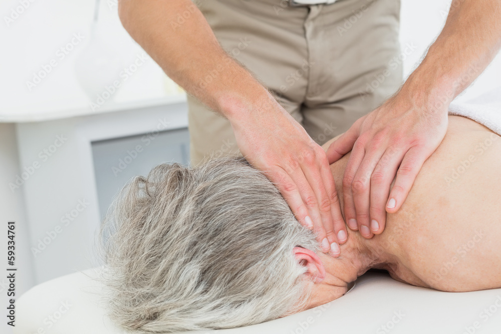 Fototapeta premium Physiotherapist massaging a senior woman's neck