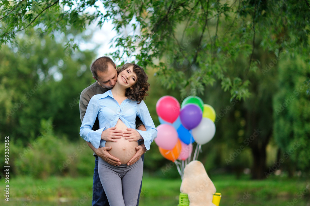 Happy future parents on the walk in summer park Happy future parents on the walk in summer park