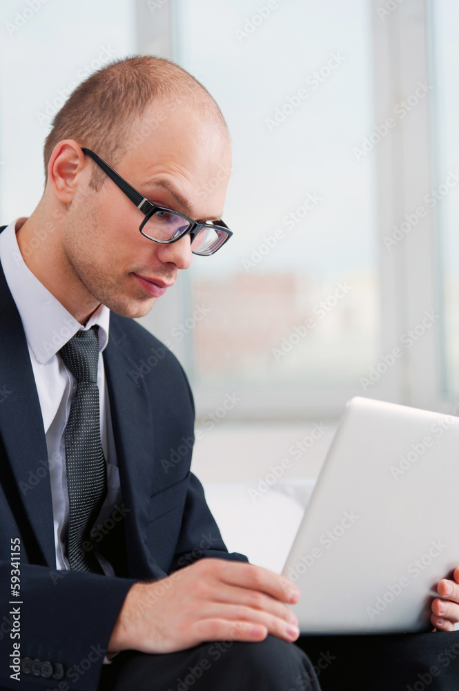 Young businessman searching with laptop on the Internet Young businessman searching with laptop on the Internet
