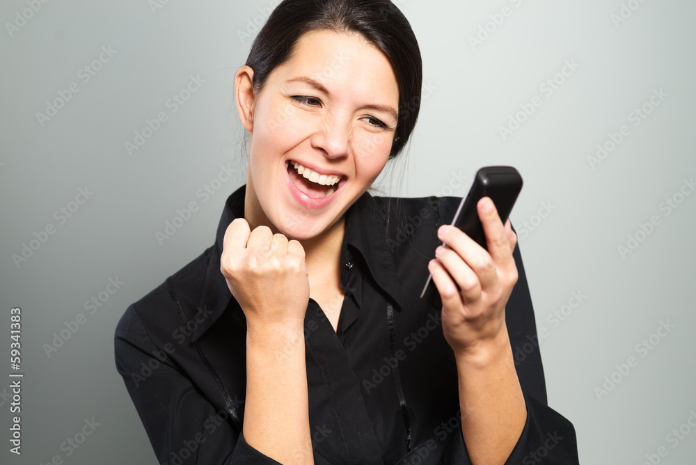 Frau jubelt aufgrund guter Neuigkeiten am Telefon Frau jubelt aufgrund guter Neuigkeiten am Telefon