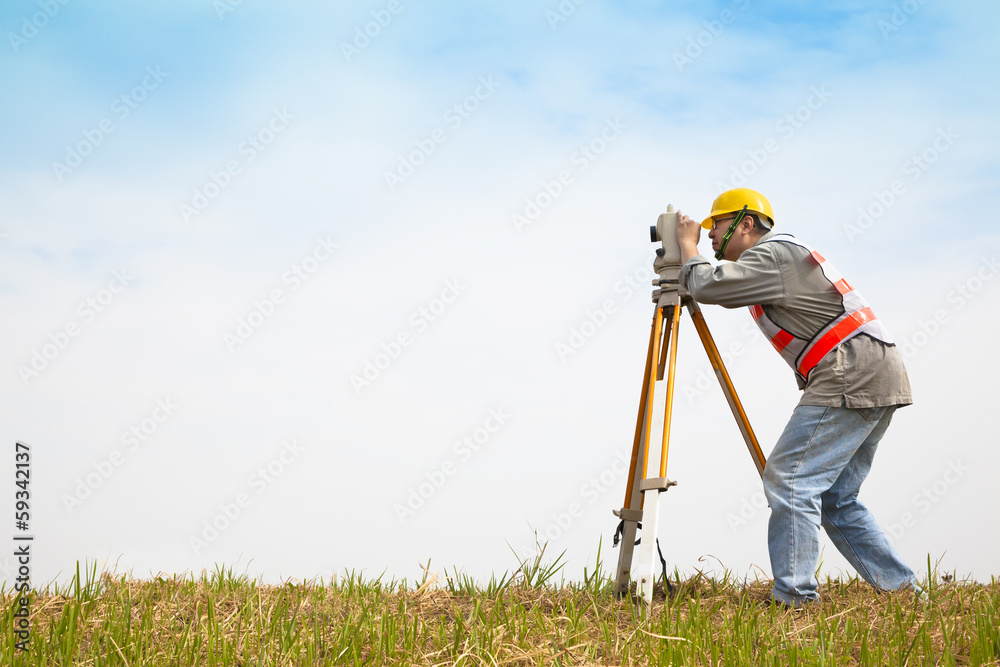 Surveyor engineer making measure on the field - obrazy, fototapety, plakaty 