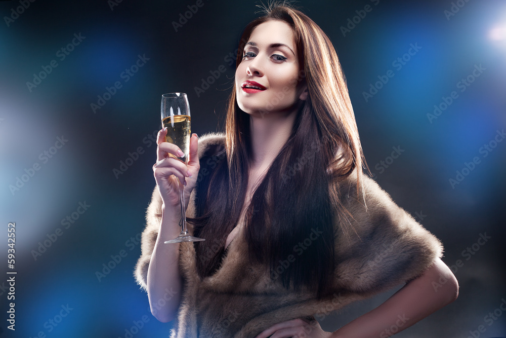 Rich woman hold glass of Champagne wearing in winter fur coat Rich woman hold glass of Champagne wearing in winter fur coat