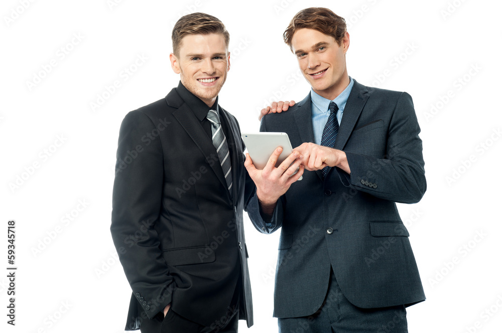 Businessmen browsing on tablet device Businessmen browsing on tablet device