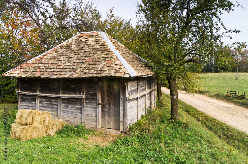Old wooden barn by a gravel mountain road, Bobija mountain