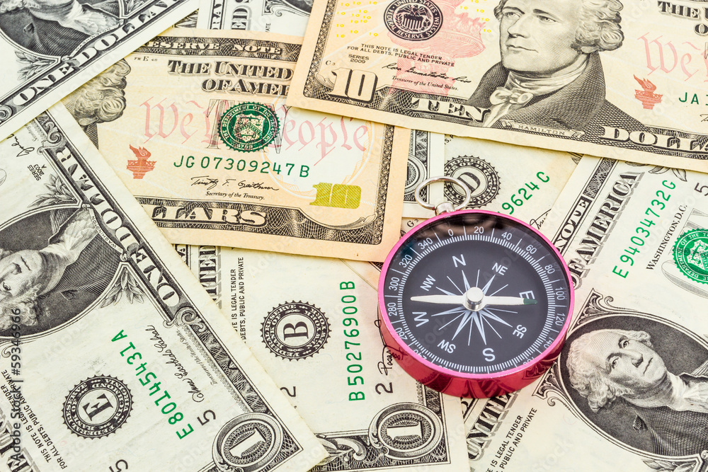 Compass on a heap of paper dollars. Compass on a heap of paper dollars.