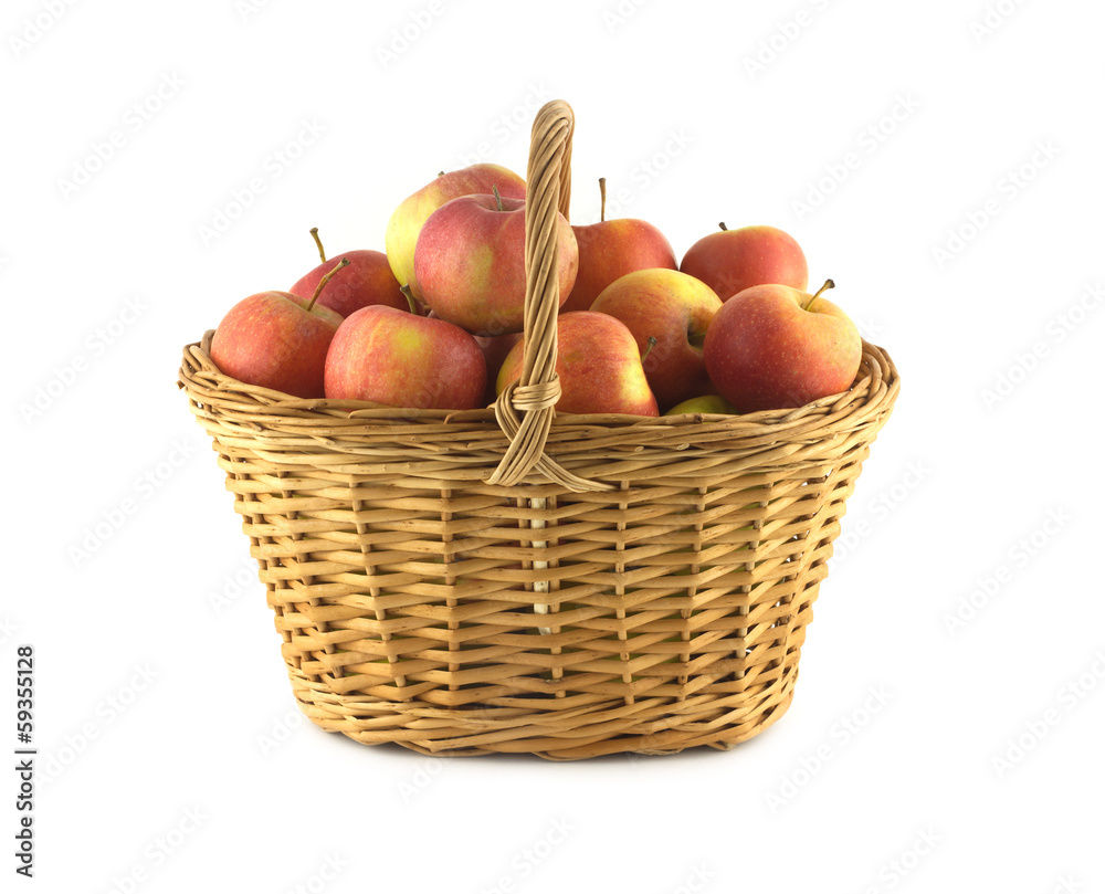 Handmade wicker basket full of ripe apples isolated closeup Handmade wicker basket full of ripe apples isolated closeup
