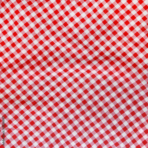 Abstract background texture of a red and white checkered fabric.