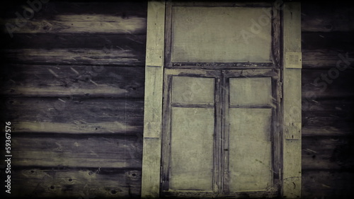 Snowing against the window of an old wooden blockhouse