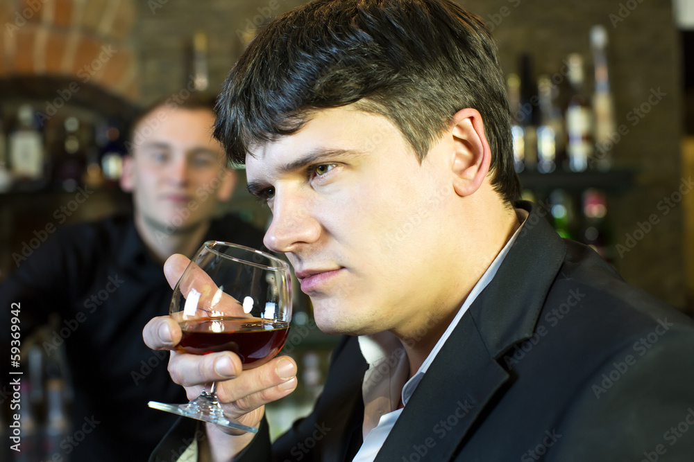young man drinking brandy at the bar
