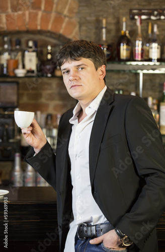 Young man drinking coffee in a bar