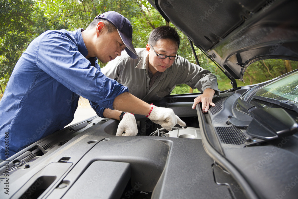 Auto mechanic fixes a car in service Auto mechanic fixes a car in service