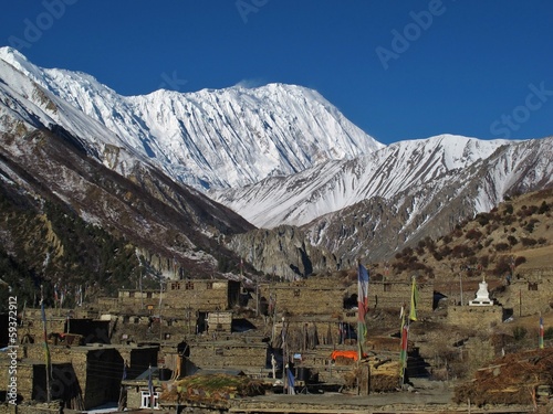 Old houses of Khangsar and snow capped Tilicho Peak photo