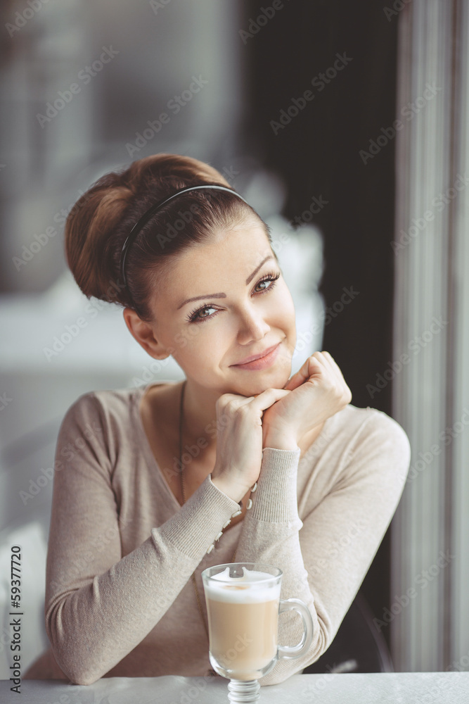 pretty young woman sitting in a cafe with a cup of coffee latte pretty young woman sitting in a cafe with a cup of coffee latte