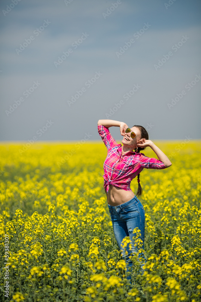 Young beautiful woman in flowering field in summer. Outdoors Young beautiful woman in flowering field in summer. Outdoors