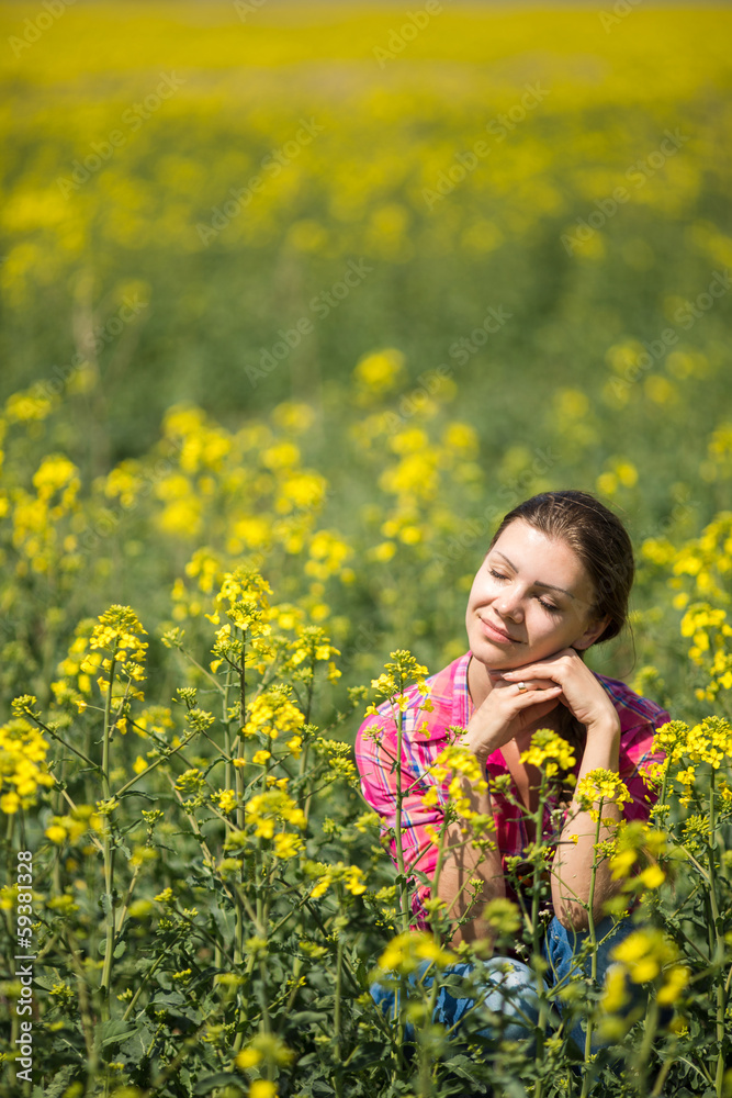 Young beautiful woman in flowering field in summer. Outdoors Young beautiful woman in flowering field in summer. Outdoors